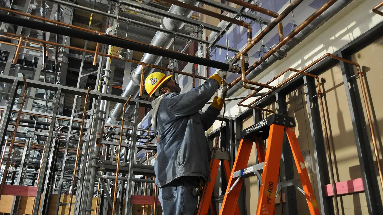 Static mixer: worker on scaffolding installing pipes